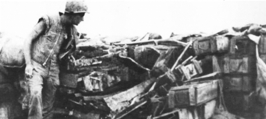 Buffalo marine inspects a collapsed con thien bunker made of dirt filled ammunition boxes